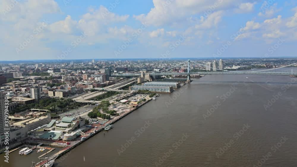 Aerial view of cars and traffic driving bridge roads and infrastructure city along Delaware river Philadelphia PA skyline with expressway on boardwalk along the pedestrians