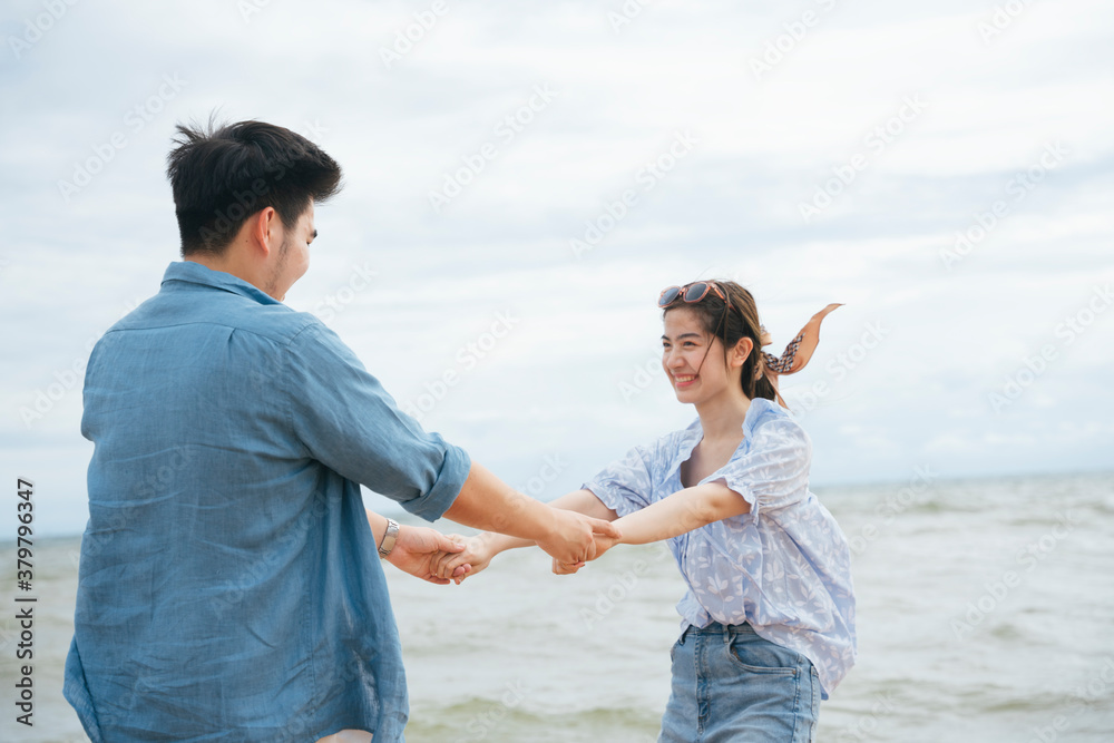 Happy romantic asian couple traveler holding hands dance on the beach. Happy romantic asian couple traveler holding hands dance on the beach.