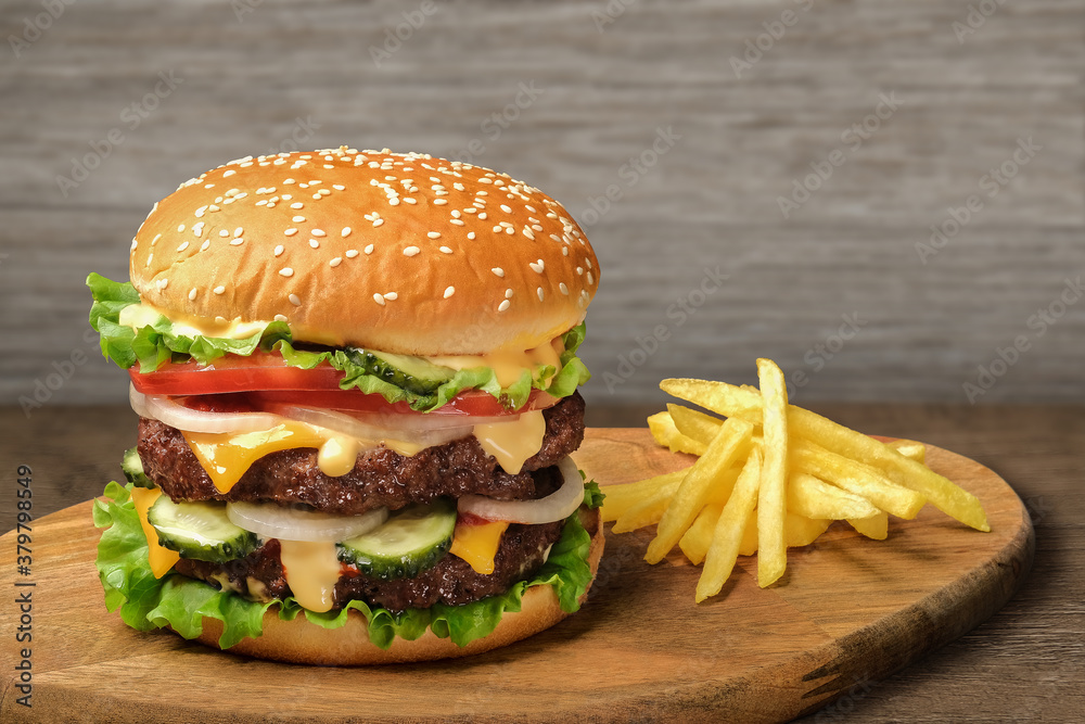 Φωτογραφία Grilled tasty beef burger with french fries on wooden rustic table against light wood wall background