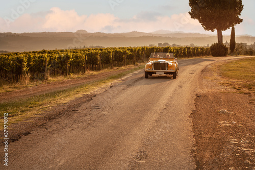 Road trip by old fashoned car on Tuscan hills photo
