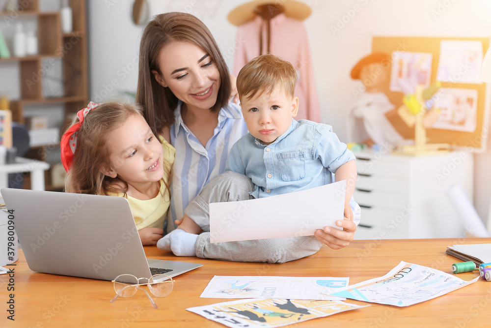 Working mother with naughty little children in atelier Working mother with naughty little children in atelier
