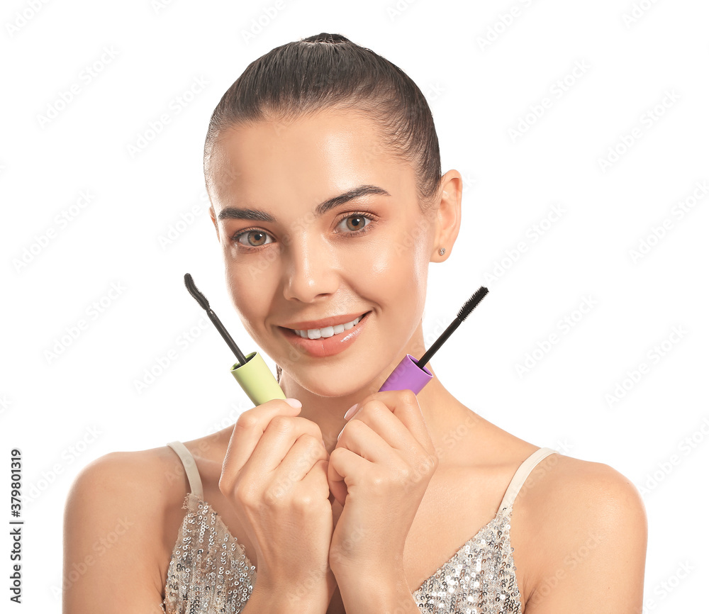 Beautiful young woman with mascara against white background