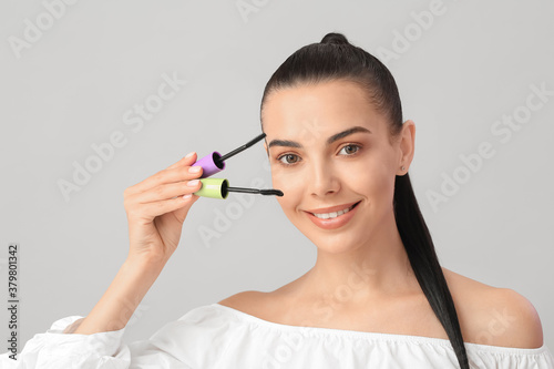 Wallpaper Mural Beautiful young woman with mascara against light background Torontodigital.ca