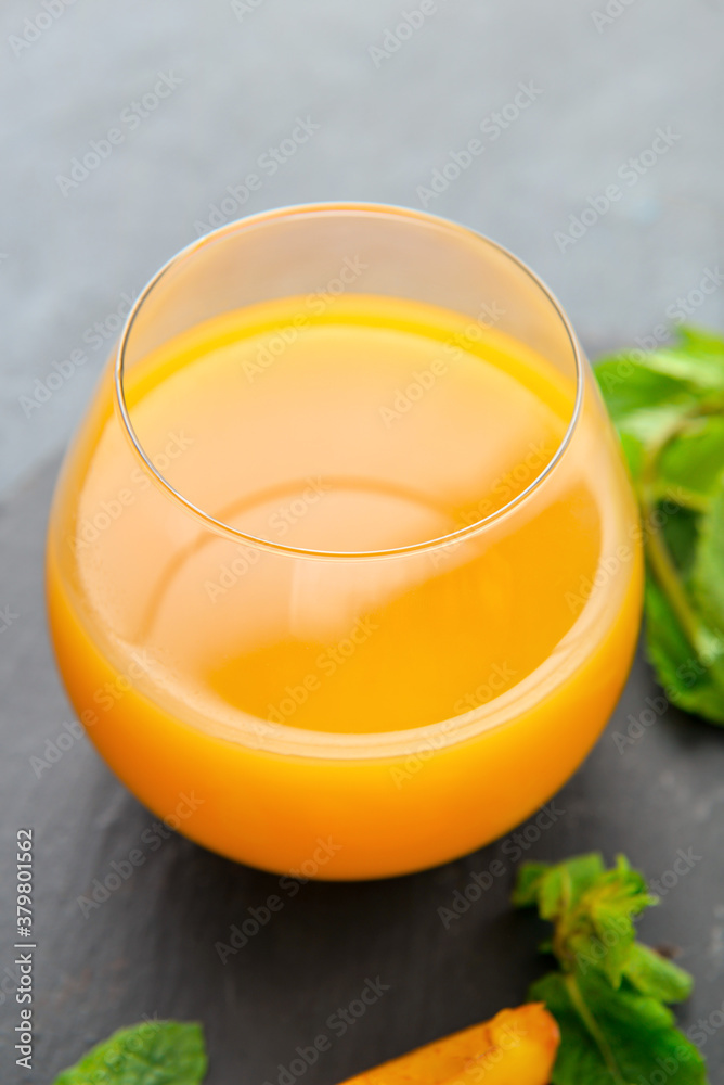 Glass of fresh peach juice on table