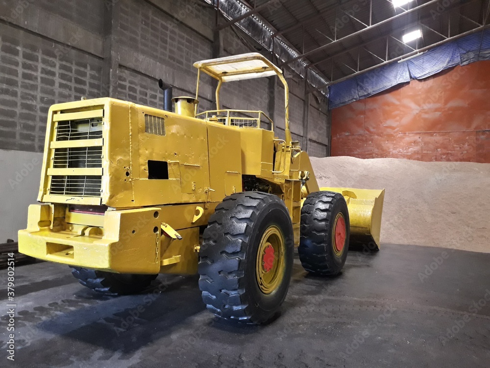 Big yellow car loader in the warehouse.