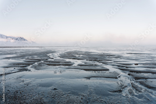 the low tide in the North sea in winter on a frosty day exposed the bottom with sand and ice