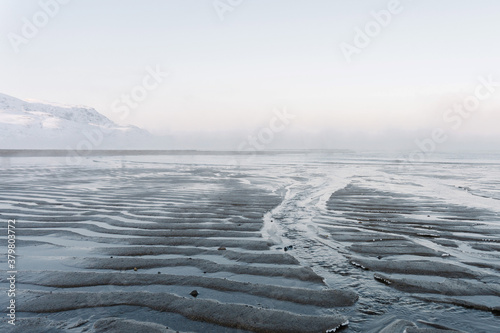 the low tide in the North sea in winter on a frosty day exposed the bottom with sand and ice