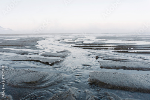 the low tide in the North sea in winter on a frosty day exposed the bottom with sand and ice