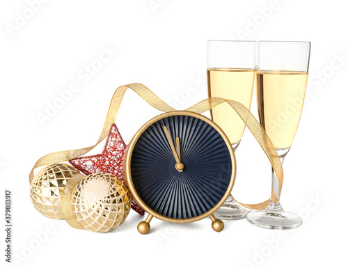 Alarm clock, Christmas decor and glasses of champagne on white background © Pixel-Shot