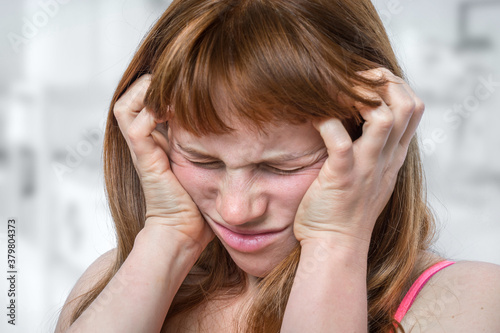 Woman with headache or migraine is holding her aching forehead