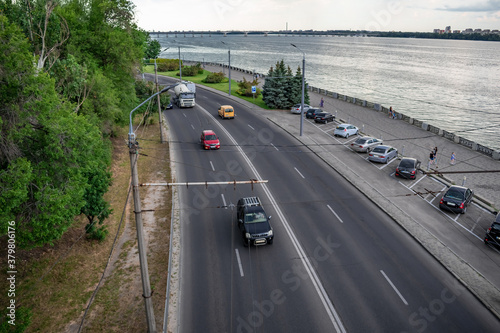 Dnipro  Ukraine - July 21  2020  Top view of the highway with cars along the Sicheslavskaya embankment in Dnipro. Cityscape with  a street against the background of the silvery water of Dnieper river