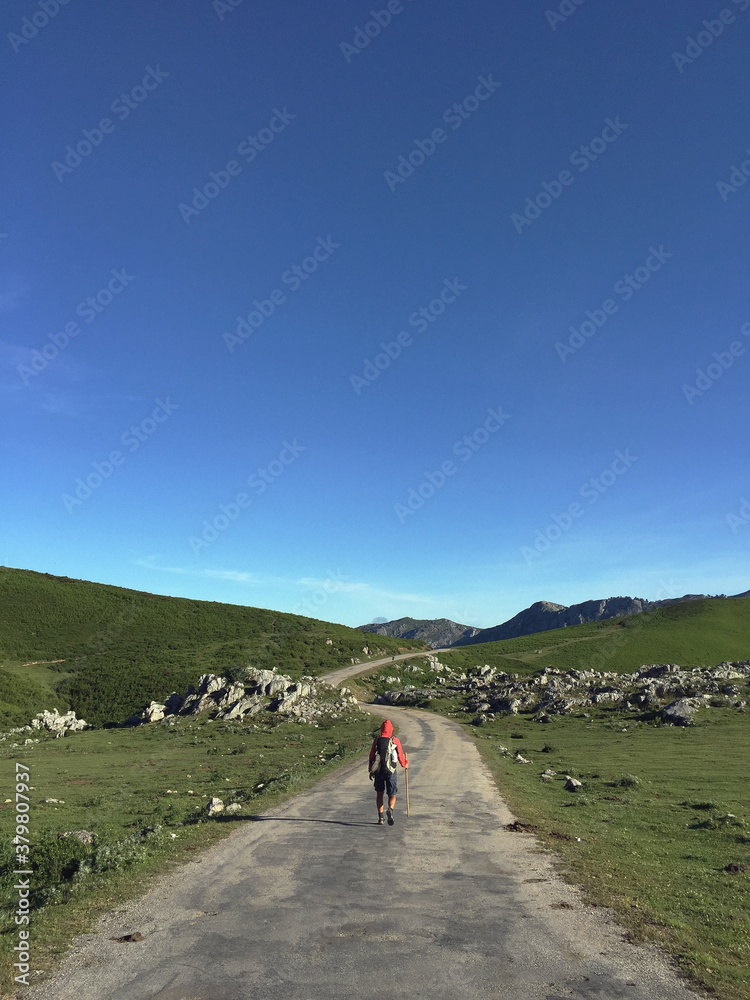 Lonely pilgrim walking in a mountain trail Lonely pilgrim walking in a mountain trail