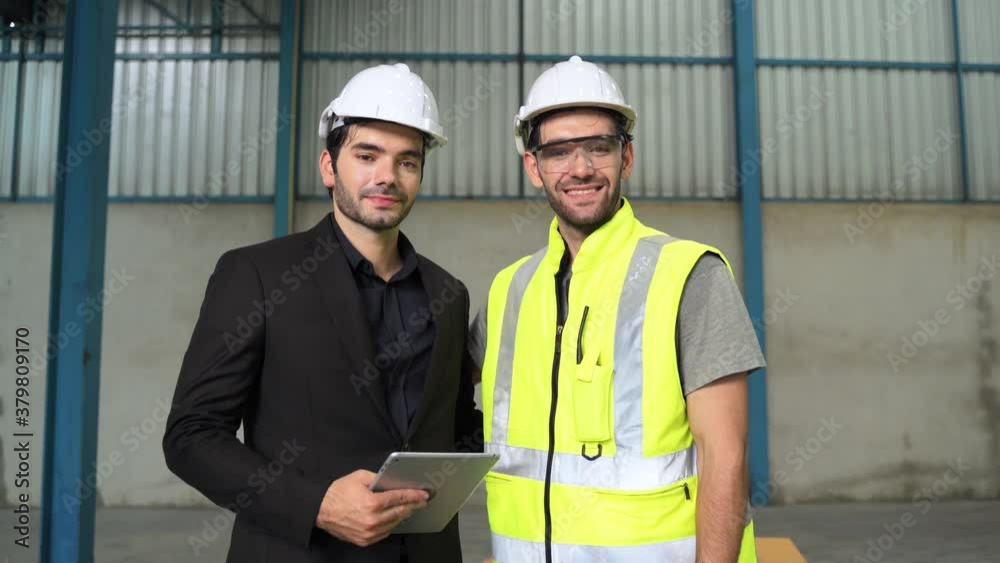 Portraits, engineers and Inspector stand smiling confidently in the warehouse.

