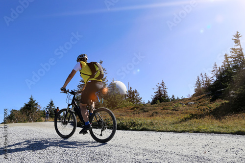 Fototapeta Naklejka Na Ścianę i Meble -  Mountainbiker auf dem Gipfel des Großer Arber, mit 1.456 m. ü. NHN. höchster Gipfel im Bayerischen Wald