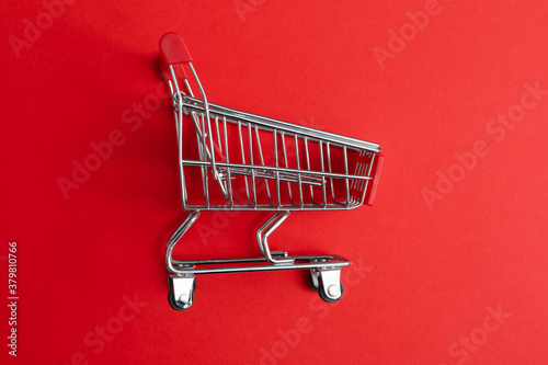 Blank shop trolley on red background, close up