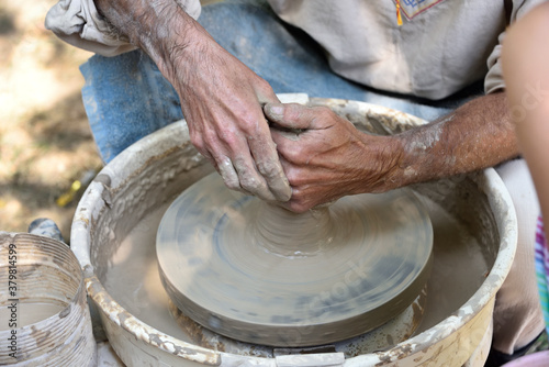 Master potter using a potter's wheel creates a vase from clay