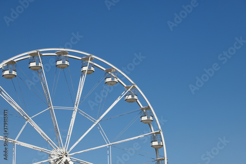 White ferris wheel against a blue sky background