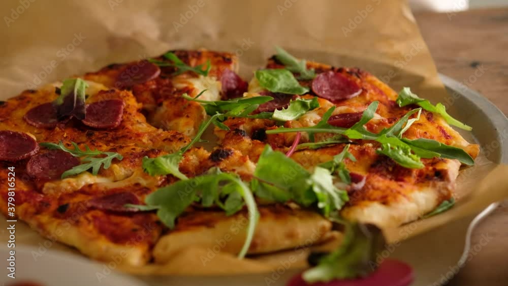 Female hands sprinkle pizza with greens, prepare Italian pizza with sauce, tomatoes, seasonings, pepperoni sausage, spinach, greens, cheese mozzarella. Dough for bread. Pizza pepperoni.