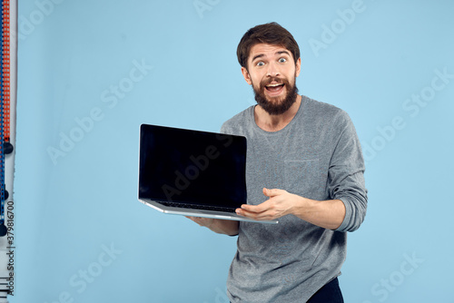 Bearded man laptop in hand internet wireless technology emotions blue background