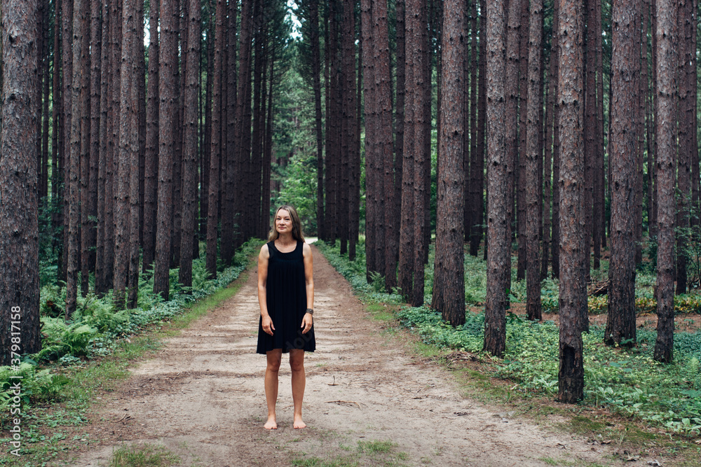 Woman standing on a road in the woods Woman standing on a road in the woods