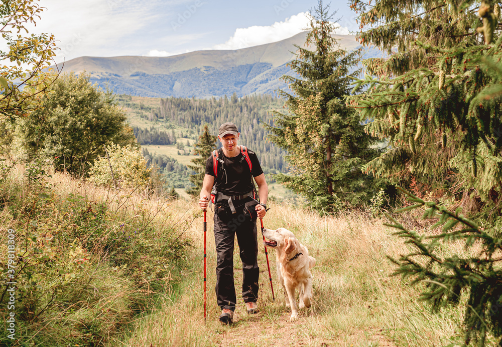 Hiker with dog walking along path