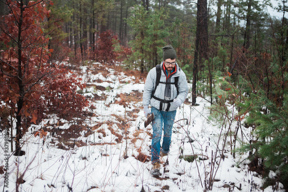 A Man Hiking Through A Forest In The Winter A Man Hiking Through A Forest In The Winter