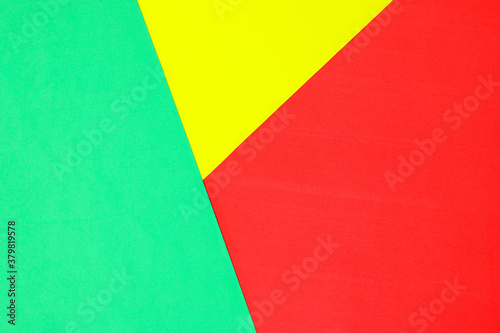 An abstract geometric textured background of green, yellow and red created with overlapping foam craft paper 