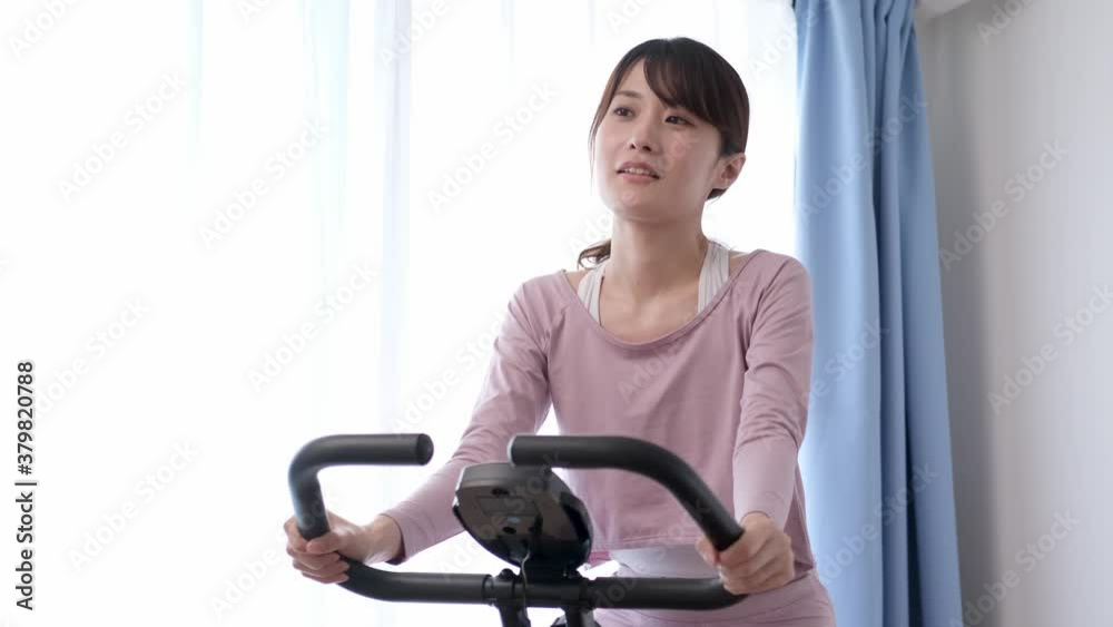 エアロバイクをこぐ女性 エアロバイクをこぐ女性