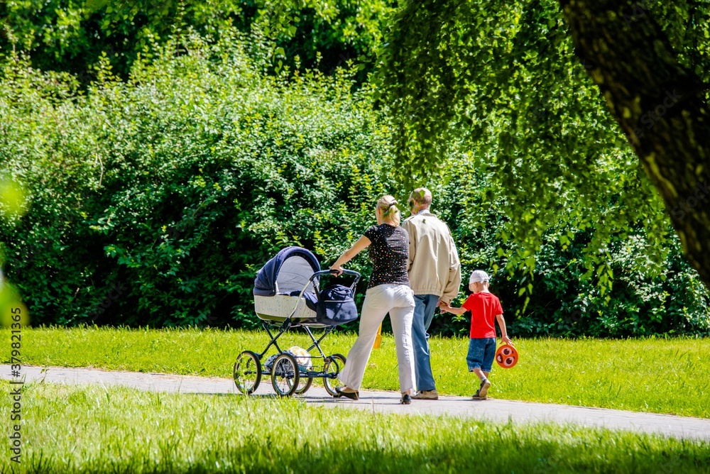 A married couple rolls a baby stroller in a city Park A married couple rolls a baby stroller in a city Park