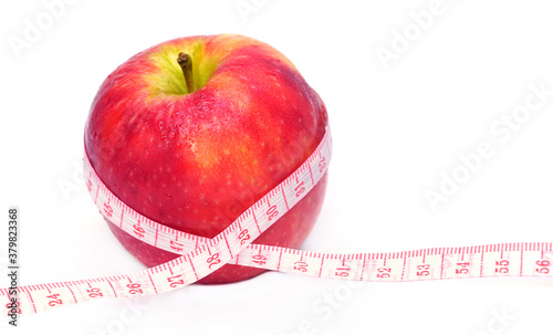 Loss weight, slim body, healthy diet concept. Measure tape and fresh fruit apple close up on white background with copy space for text.