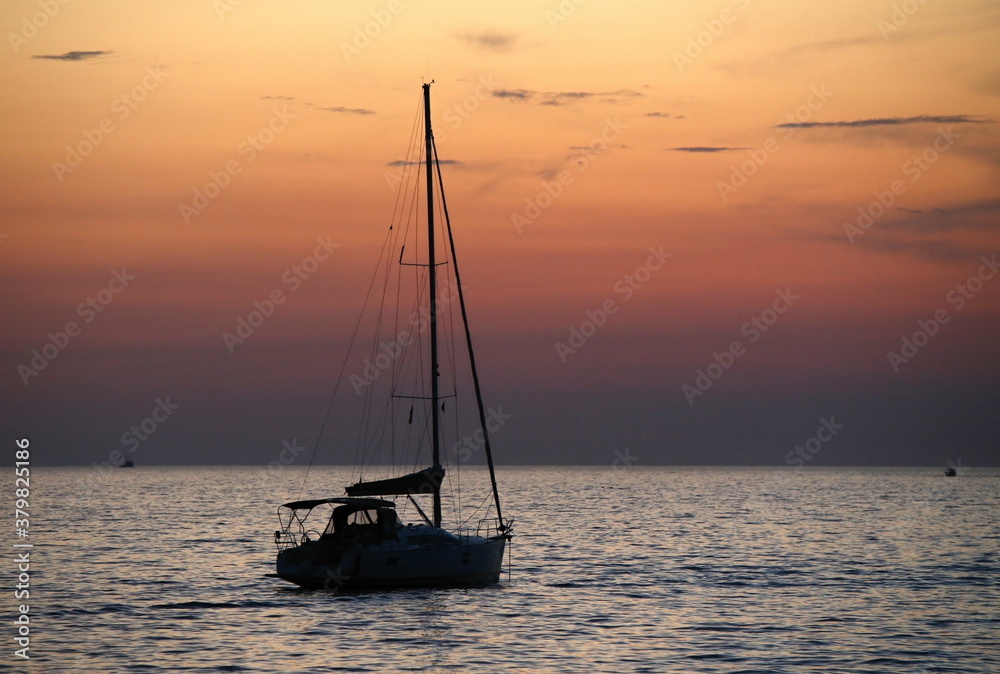 Silhouette of the boat against orange evening sky
