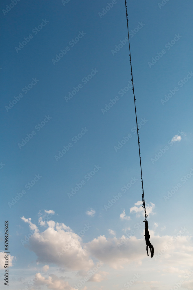 Woman hangs upside down from a bungee cord Woman hangs upside down from a bungee cord