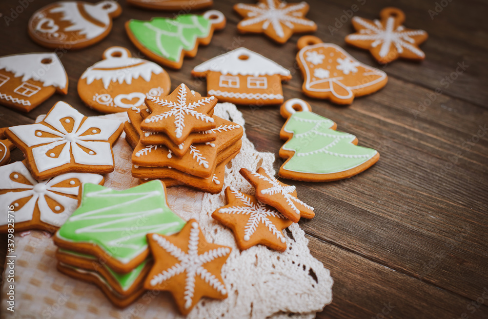 festive Christmas gingerbread cookies in the shape of a star lie on a wooden dark brown background.