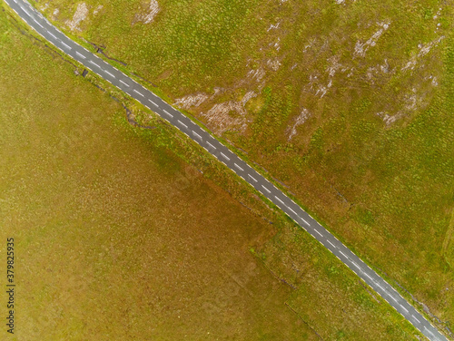 Aerial top down view on a small road between wild fields, West of Ireland.