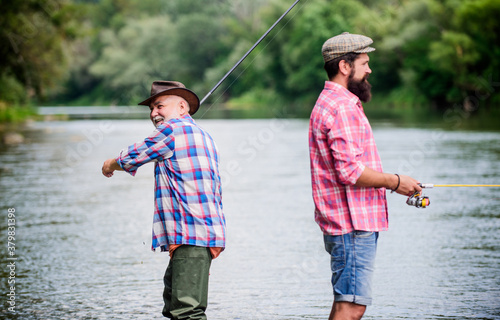 Summer weekend. Peaceful activity. Nice catch. Rod and tackle. Fisherman fishing equipment. Fisherman grandpa and mature man friends. Fisherman family. Hobby sport activity. Father and son fishing