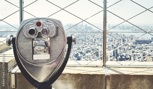 Coin operated binoculars with Manhattan skyline in background, retro color toning applied, New York City, USA.