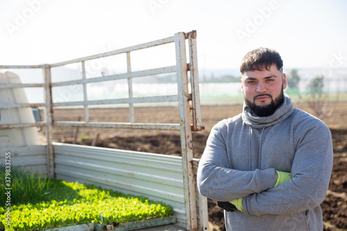 Portrait of farmer near to car with lettuce seedlings. High quality photo