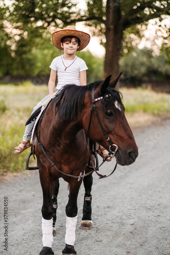 Boy with hat riding a horse outdoors. Pet therapy © sushytska
