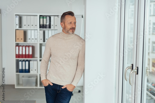 Trendy businessman standing deep in thought
