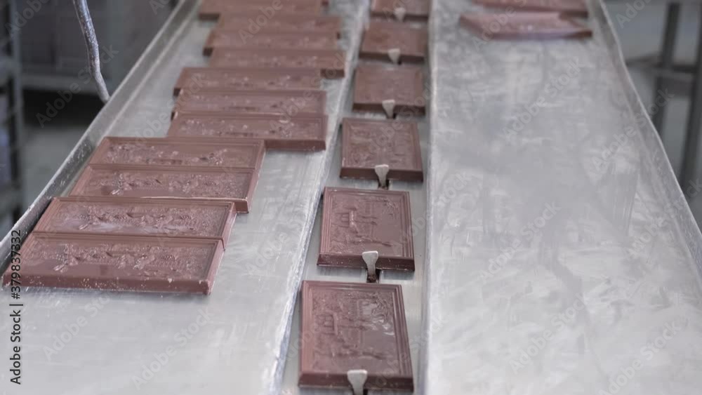Factory made packaged chocolate bar. Automatic packaging chocolate process. Dairy factory, production of chocolate bars in wrappers.Modern technologies. Factory made packaged chocolate bar. Automatic packaging chocolate process. Dairy factory, production of chocolate bars in wrappers.Modern technologies.