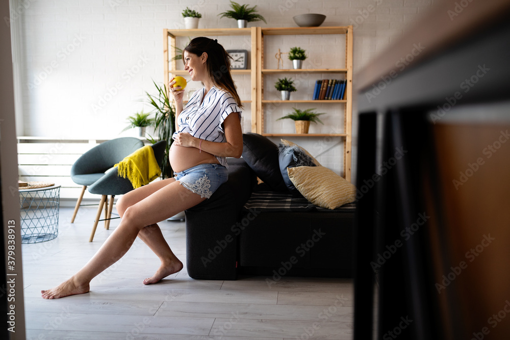 Beautiful pregnant woman eating healthy food at home Beautiful pregnant woman eating healthy food at home