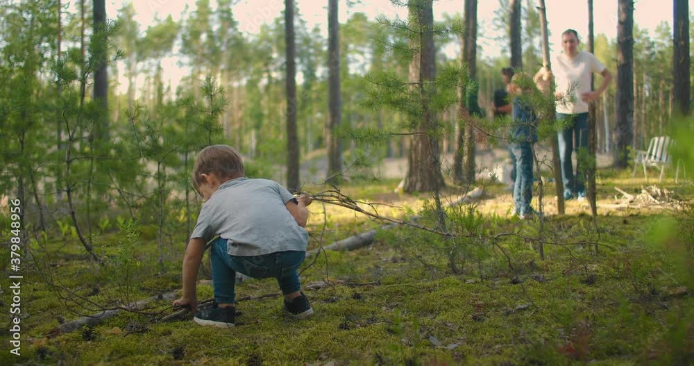 Two little boy collecting firewood in the forest. Two little brothers in the forest gather wood together and build a fire Two little boy collecting firewood in the forest. Two little brothers in the forest gather wood together and build a fire