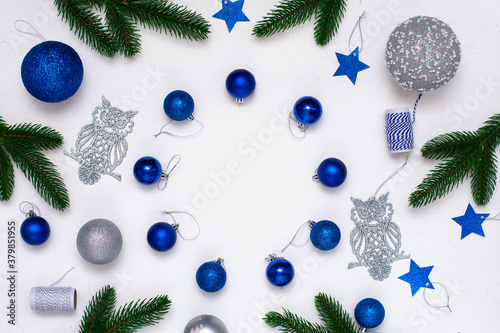Christmas flatlay with fir branches, blue and silver  decorations on white background. Christmas composition, top view, copy space. New Year background.