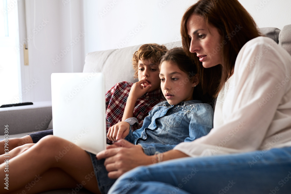 Family using laptop on couch. Family using laptop on couch.