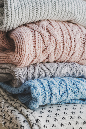 Pile of knitted woolen sweaters. Warm clothes for fall and winter season. Knitwear storage and care