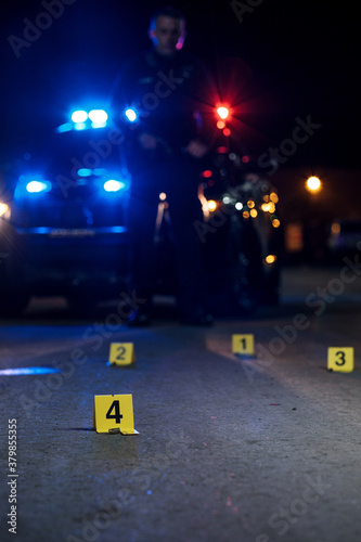 Shell casings are marked with evidence tags at a crime scene