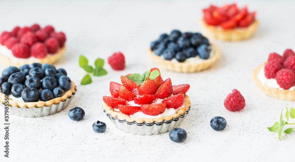 Sweet tarts with fresh summer berries, raspberries, strawberries and blueberries, selective focus - obrazy, fototapety, plakaty 