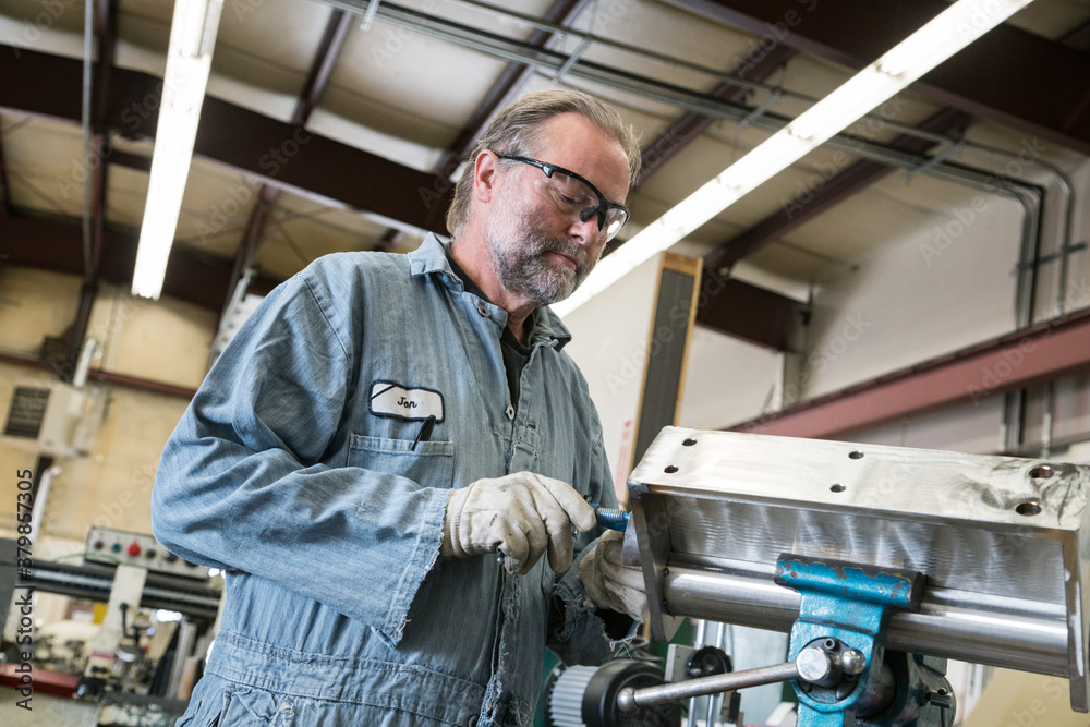 Mature factory worker working with sheet metal Mature factory worker working with sheet metal