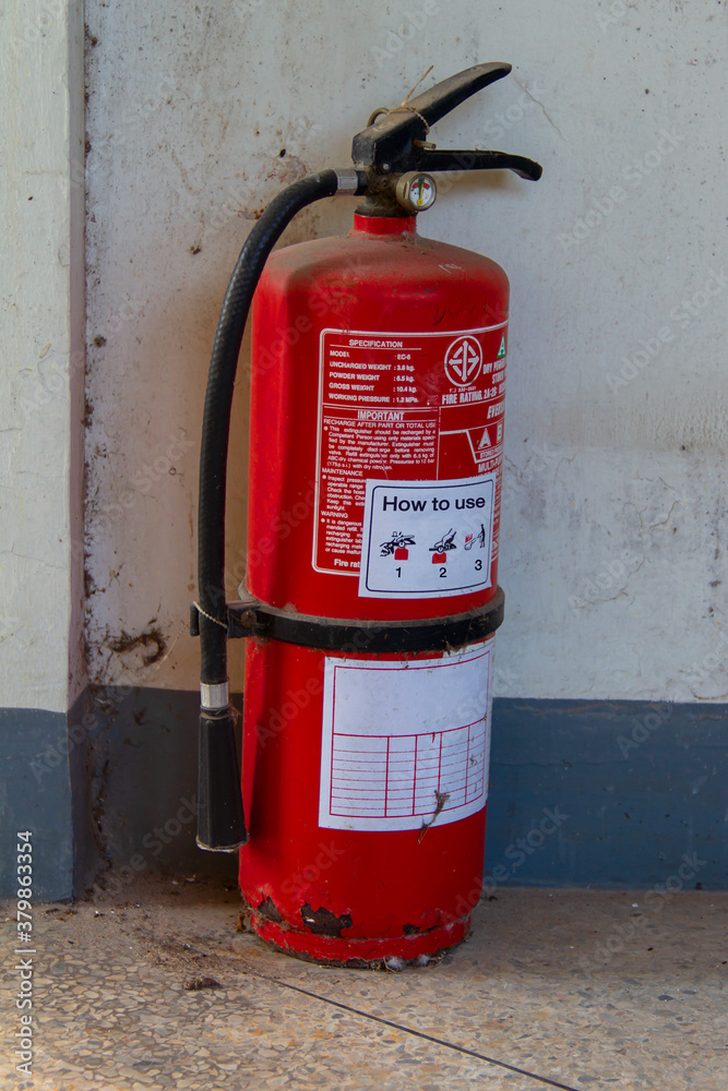 An old fire extinguisher was left on an abandoned building. That can still be used