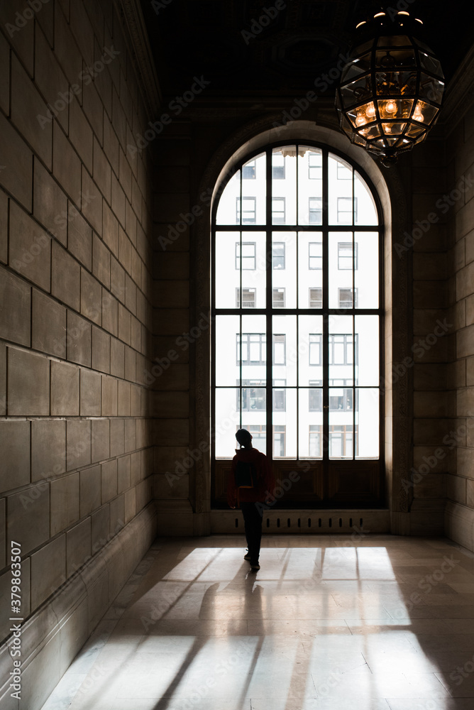 teen standing by a big window teen standing by a big window